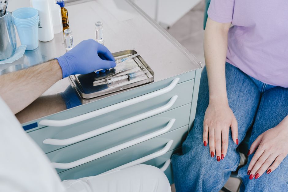 pharmacist preparing a vaccine dose for an older adult patient in a retail pharmacy