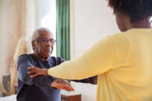 Home care nurse assisting a senior at home under the PACE program