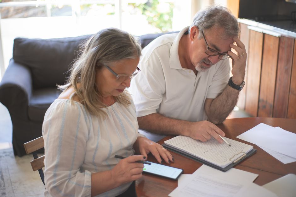 Senior couple reviewing a receipt and rebate form at a home improvement store checkout
