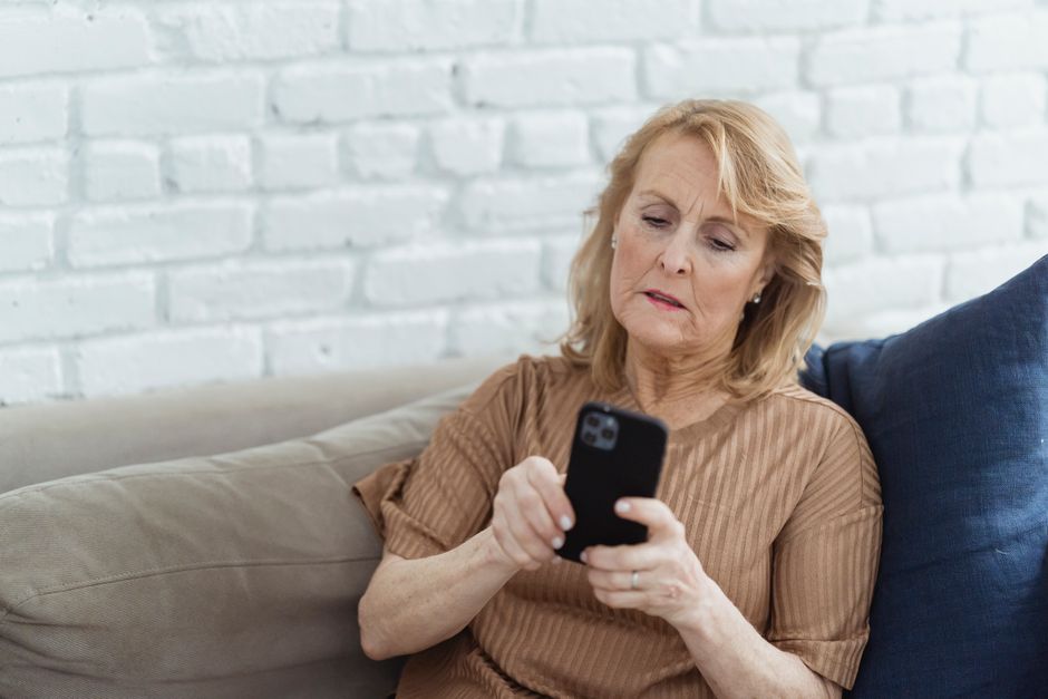 Senior traveler checking a hotel booking website on a smartphone