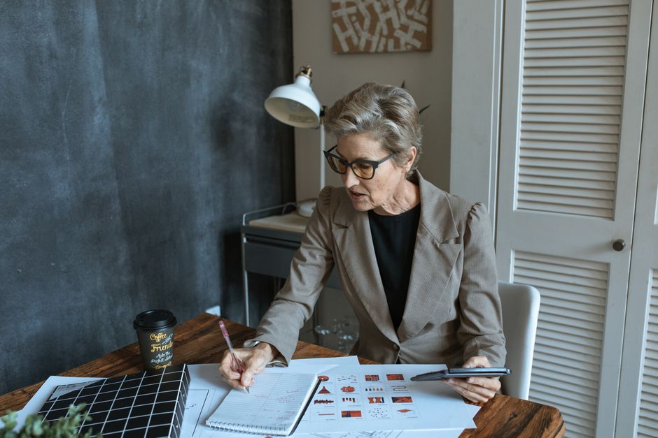 Retiree reviewing an annual financial plan and taking notes in a planner