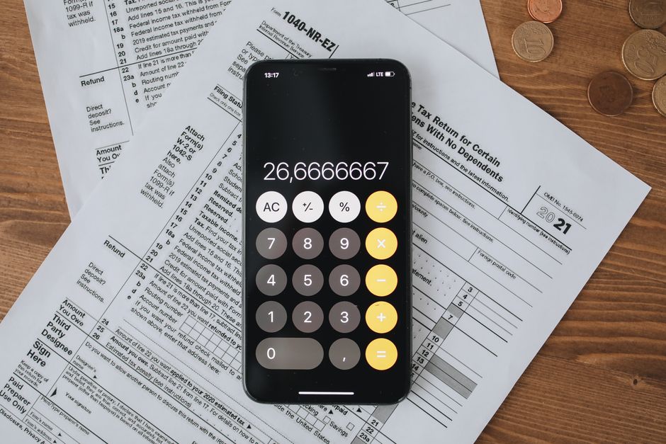 Person reviewing tax documents and a calculator to check refund tax treatment