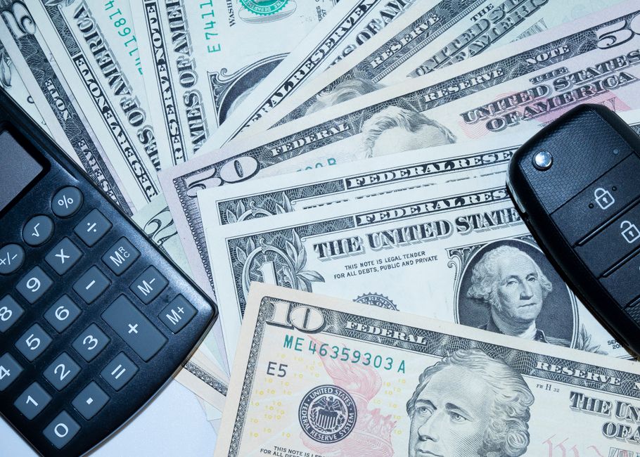 Calculator, cash and car keys on a table