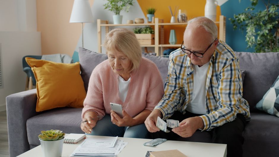 Retired woman using a calculator to check her monthly income