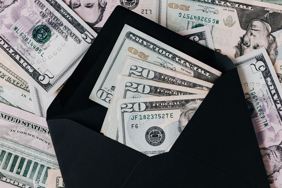 Cash in an envelope beside a holiday shopping list