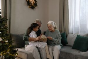 Grandparent wrapping holiday gifts at a table