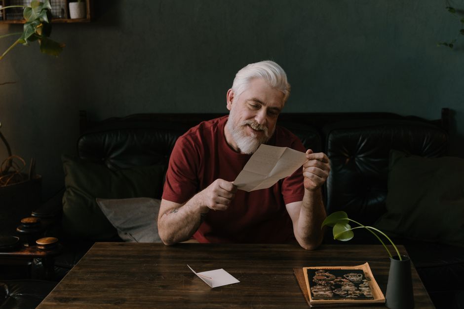 Senior man reading a letter from his insurance plan at home