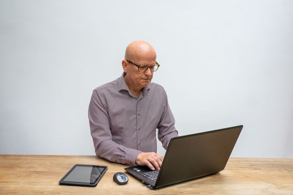 Senior getting help with tax filing on a laptop