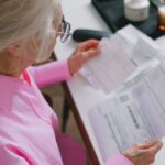 Retired woman reading tax papers at a table